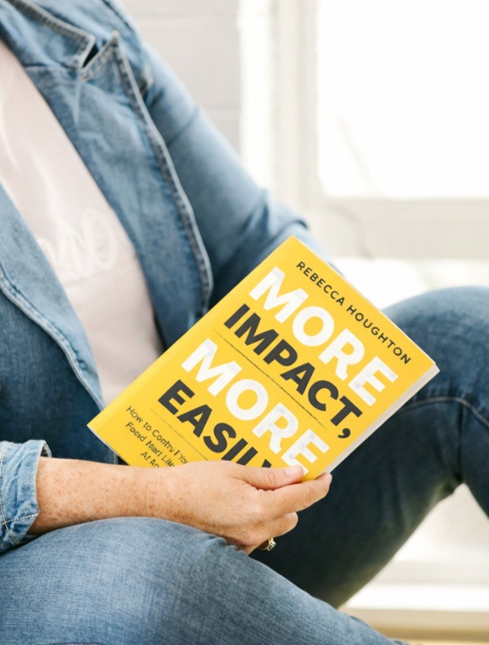 Rebecca holding her book More Impact, More Easily
